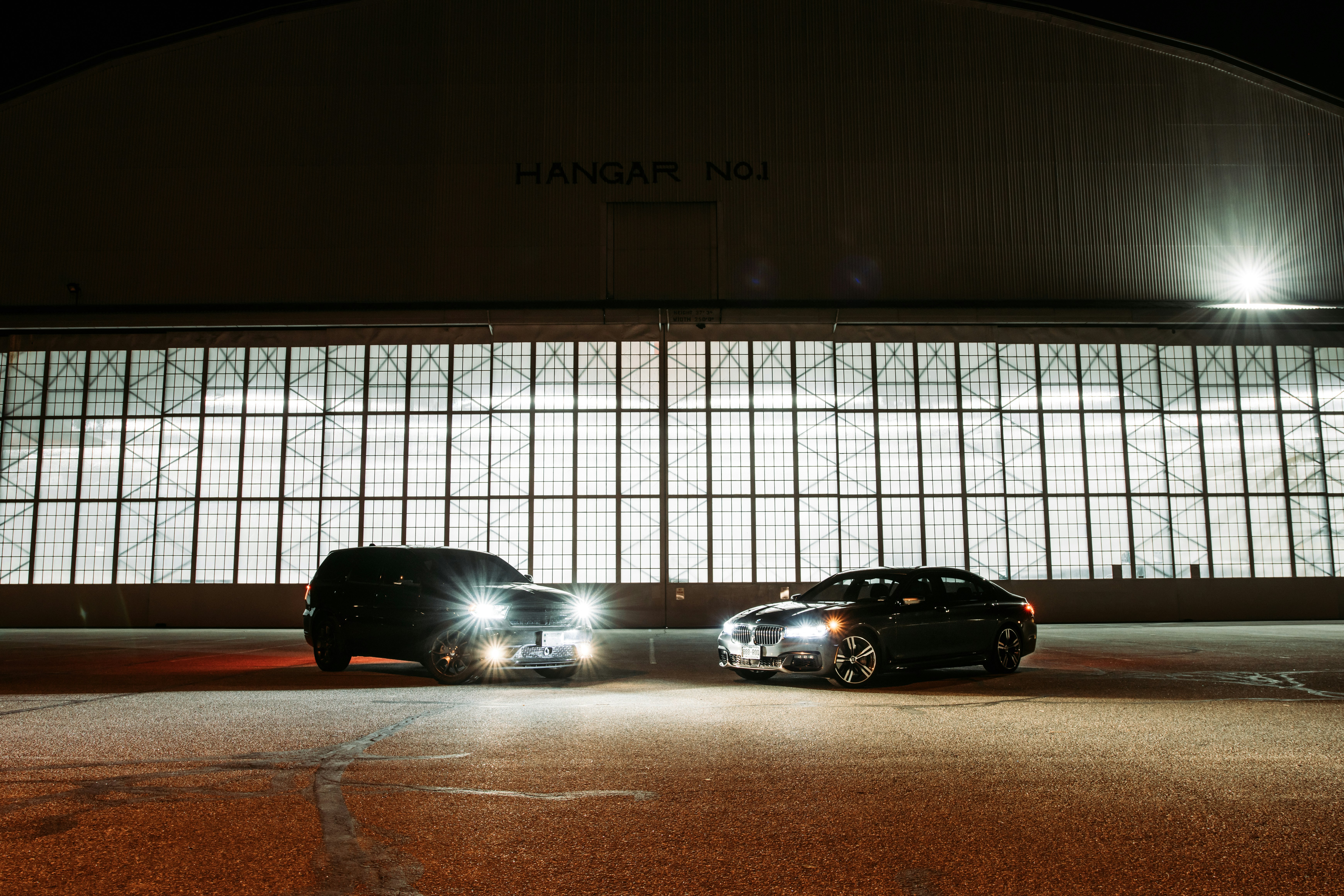 black car parked beside white wall